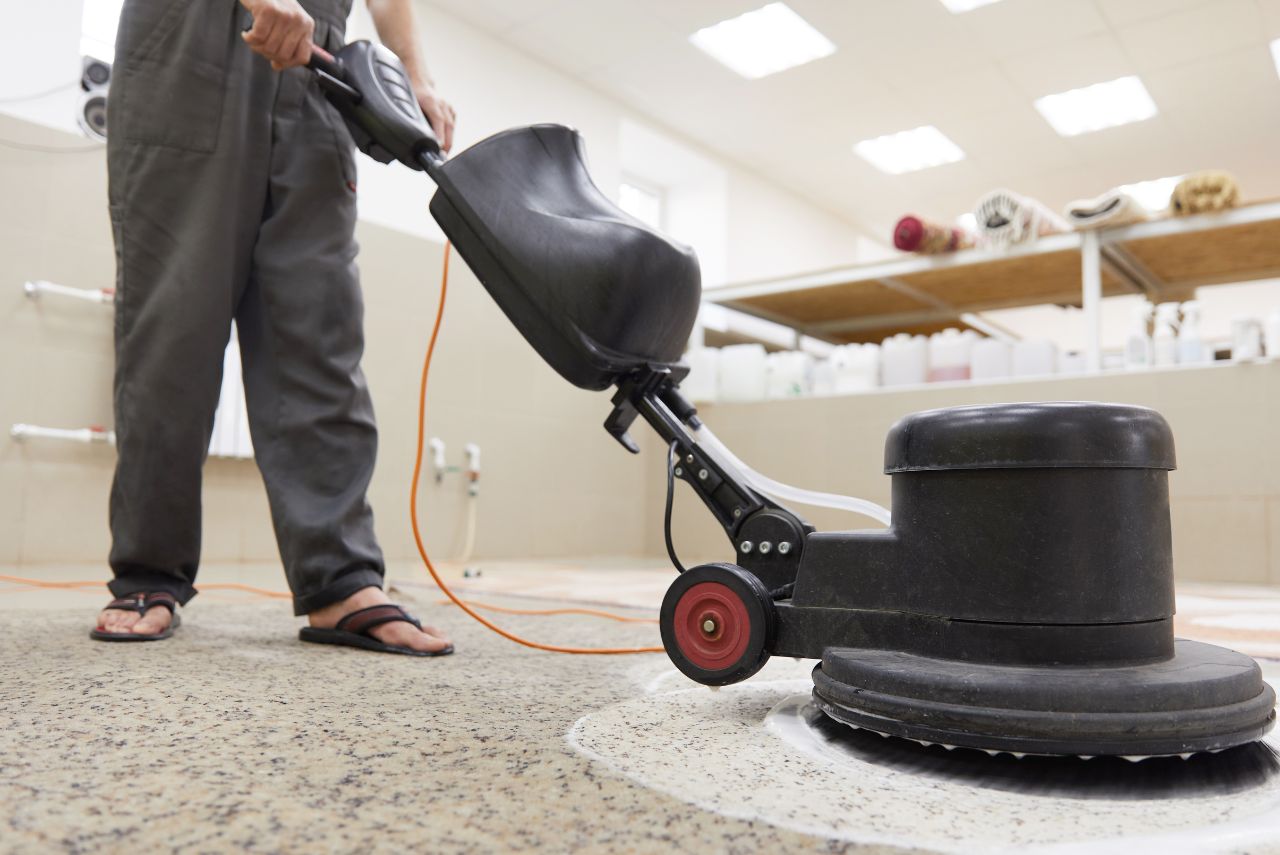 Professional technician operating an industrial floor scrubbing machine to apply SpotOn Multi Purpose Cleaner inside a commercial shop in Pretoria.